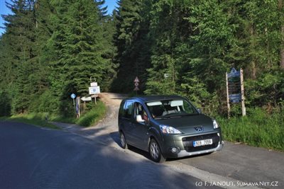 Odbočka ze silnice Lam – Lambach na lesní štěrkovanou cestu k parkovišti Osserwanderplatz – Sattel