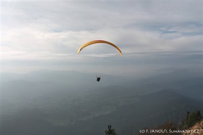 Paraglidista se po startu z Osserwiese vznáší nad údolím Weisser Regen